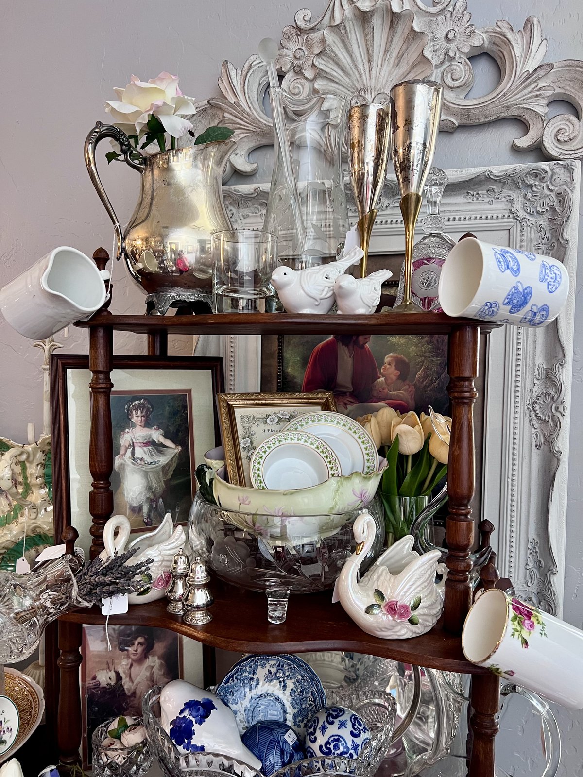 A curated shelf of vintage silver and glass
