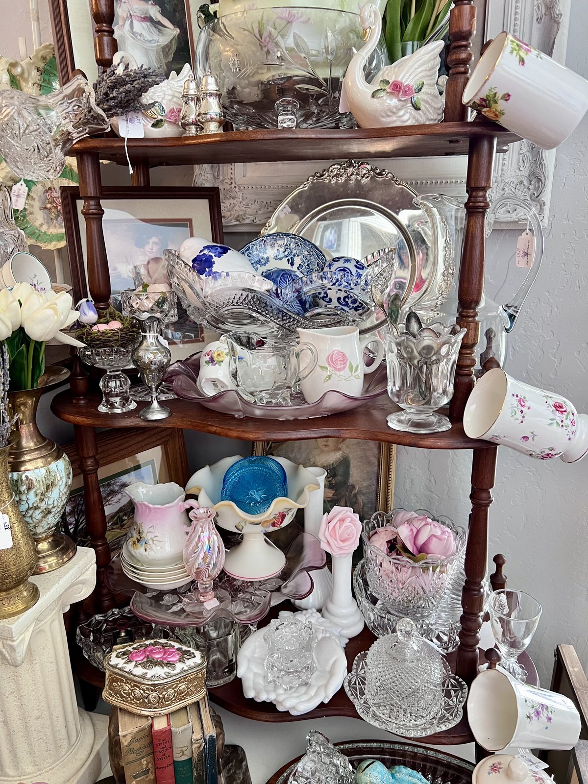 A curated shelf of vintage china and silver