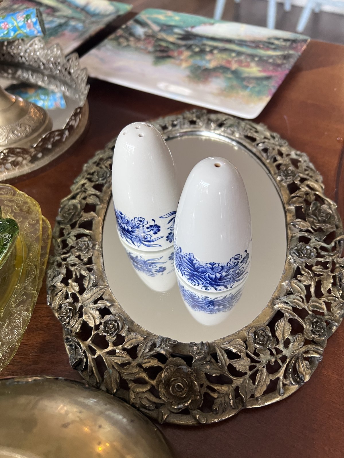 Blue and white porcelain salt and pepper shakers on a rose-etched silver mirror tray