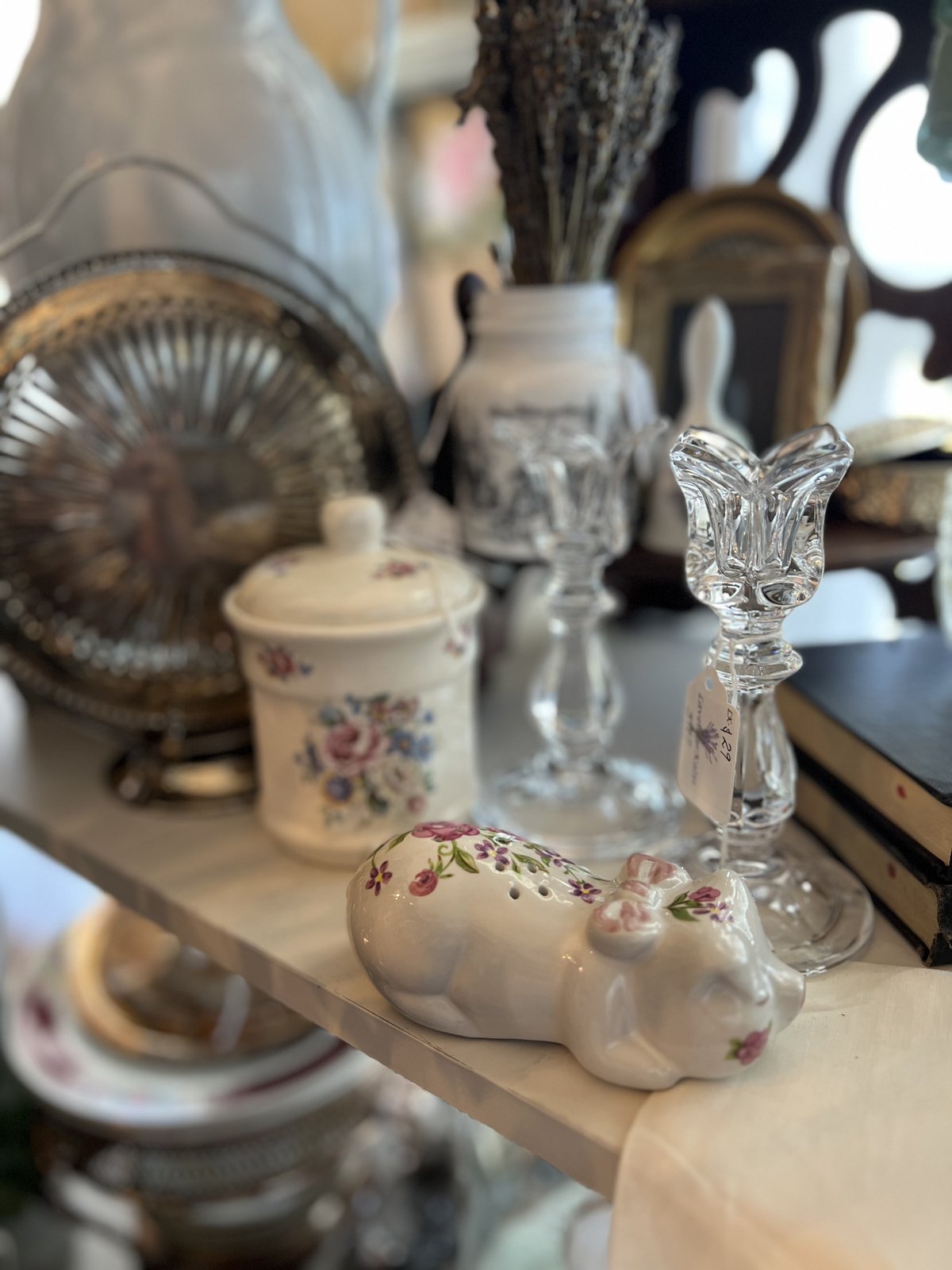 Cut crystal candlesticks with a floral trinket jar and sleeping cat figurine